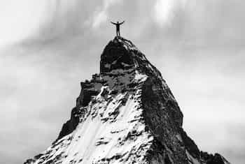Man standing on the peak of a mountain